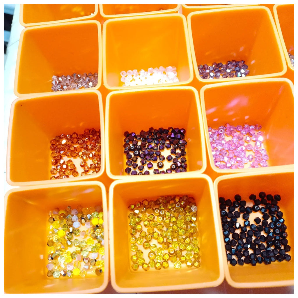 4200pcs 42 Packets 100pcs ea 4mm Bicone Beads Mixed Colours Set – Orange container with compartments filled with various colored beads and sequins on a white background