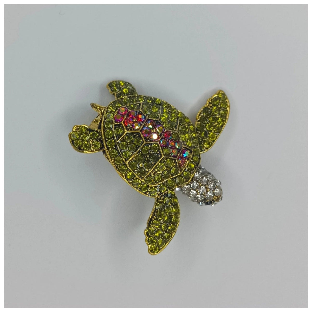 Crystal Adorned Sea Turtle Brooch with Rhinestones – Decorative turtle brooch with gemstones on a gray background